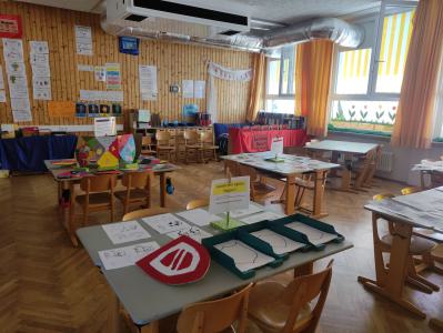 Ein gut ausgestatteter Raum mit Tischen und verschiedenen Bastelmaterialien, der für einen Workshop vorbereitet ist.