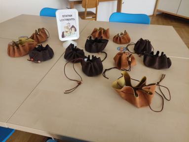 Eine Sammlung von kleinen Lederbeuteln und Taschen, die auf einem Tisch präsentiert werden.