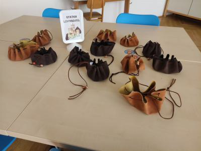 Eine Sammlung von kleinen Lederbeuteln und Taschen, die auf einem Tisch präsentiert werden.