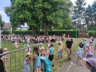 Eine große Gruppe von Menschen versammelt sich auf einer Grünfläche, um einen Tag im Park zu verbringen.